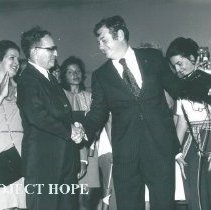 Dr William B Walsh shaking hands and Olga Verduzco behind to right.